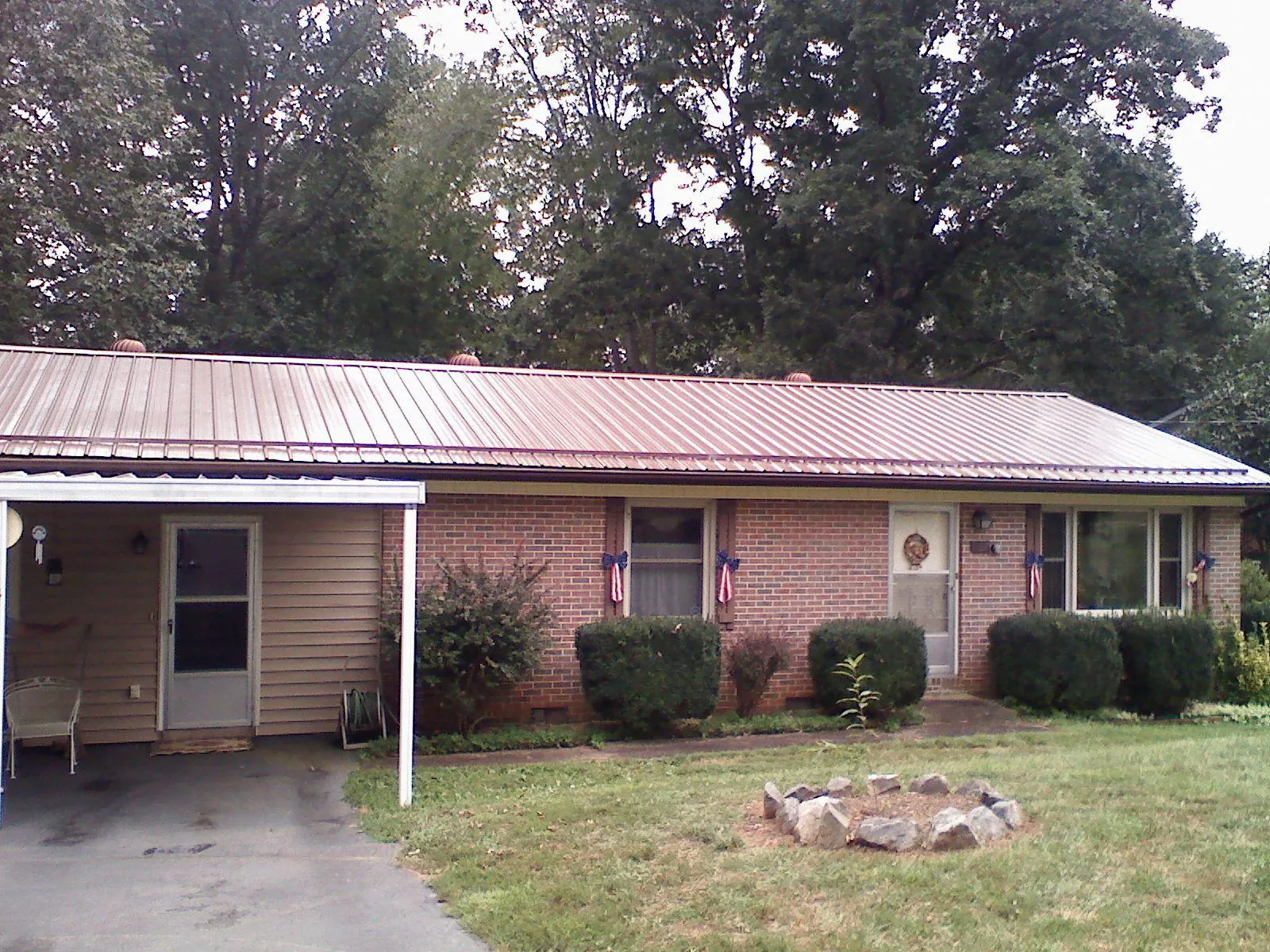 Bronze metal roof and carport on a brick ranch home — Roof Repair work by our crew in Hammett