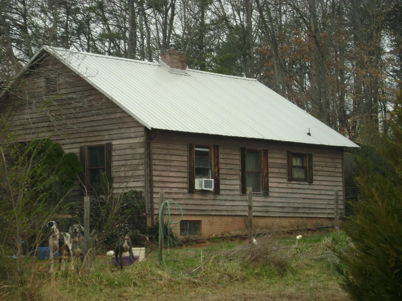 White metal roof on an old wood sided farmhouse, from a Metal Roof Installation job in Hammett